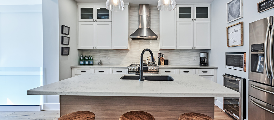 Modern white kitchen with a large island and stainless steel appliances